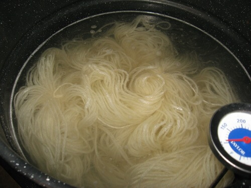 Wool yarn soaking in a pot of mordant solution