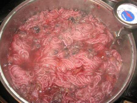 Pot filled with yarn soaking in berry juice