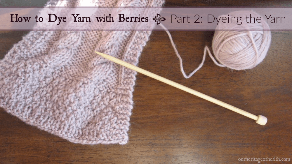 Ball of pale lavender yarn with knitting needle and end of knitted scarf