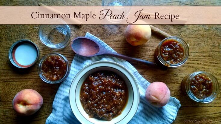 Bowl and Mason jars full of peach jam on table with peaches and spoon.